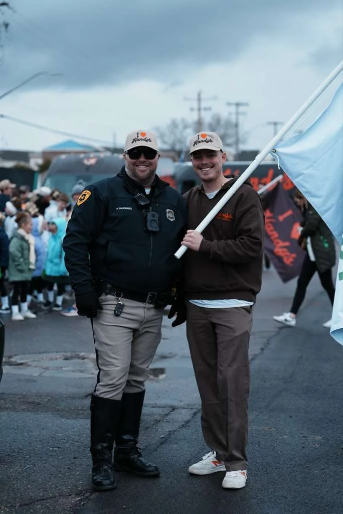 A Handy's team member with a police officer at a community parade