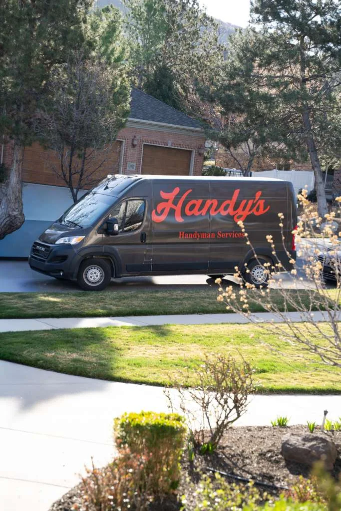 A Handy's van parked in front of a home