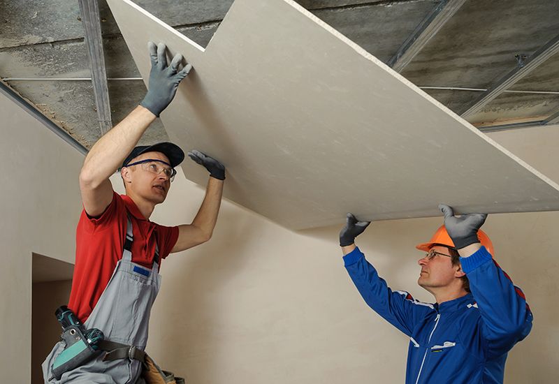 A drywall installer patching and finishing a wall