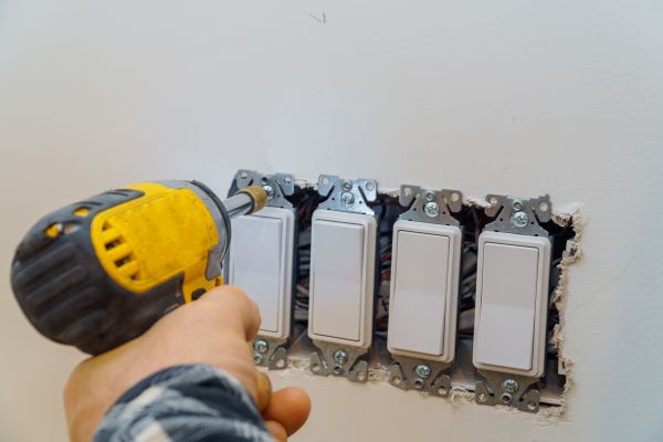 A hand pressing a wall light switch